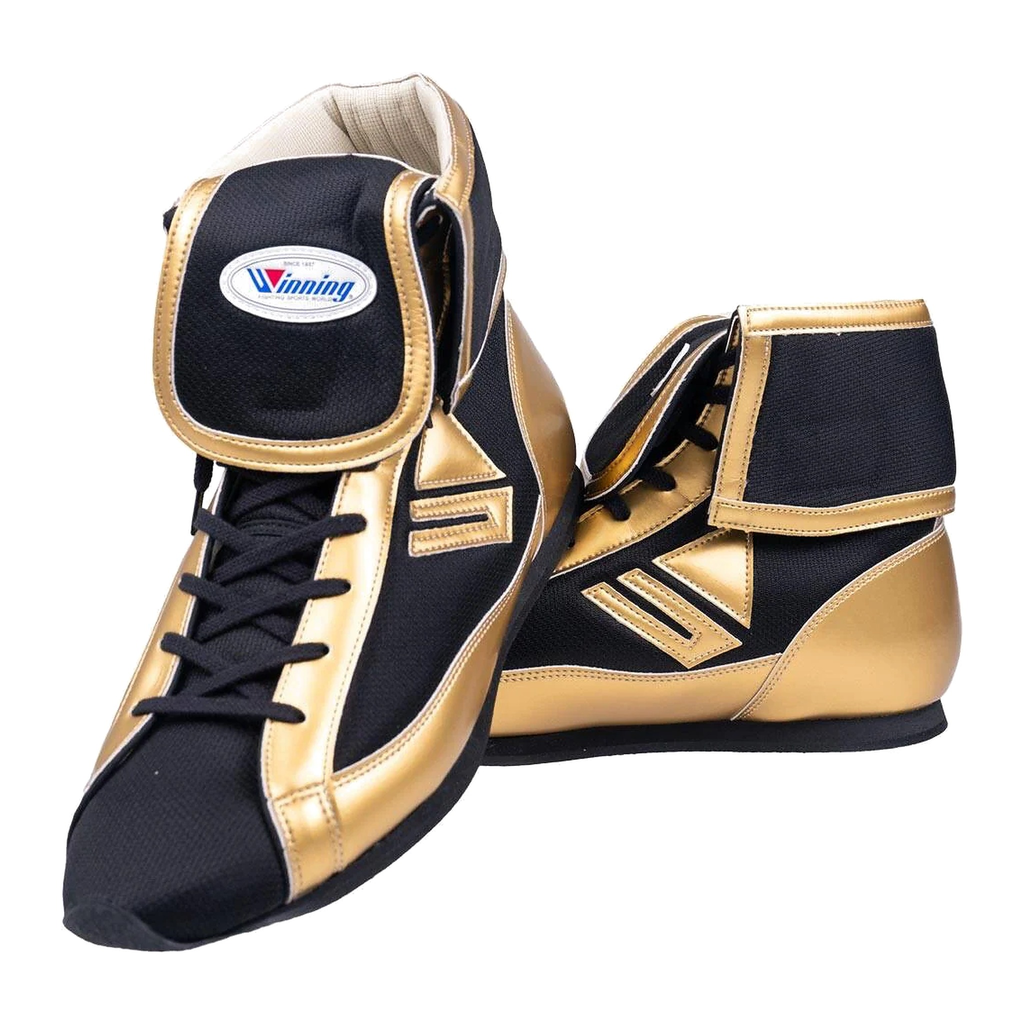 A pair of Winning boxing shoes in a black and gold colorway, featuring a high-top design and the Winning logo on the tongue, displayed on a white background.
